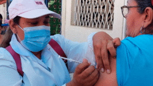 Enfermera del Ministerio de Salud de Nicaragua aplicando vacuna contra la COVID-19 a una habitante del barrio Omar Torrijos, de Managua