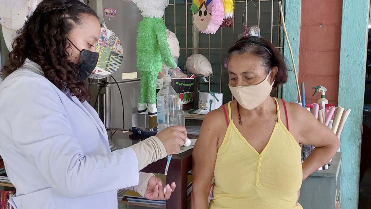 Brigadista del Ministerio de Salud aplica vacuna contra el COVID-19 a pobladora del barrio Sierra Maestra