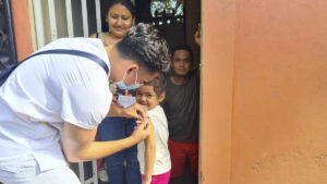 Brigadista del Ministerio de Salud aplica vacuna a una menor en el barrio Jorge Casali