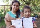 Una madre y su hija sostienen sus tarjetas de vacuna tras aplicarse una nueva dosis contra el COVID-19