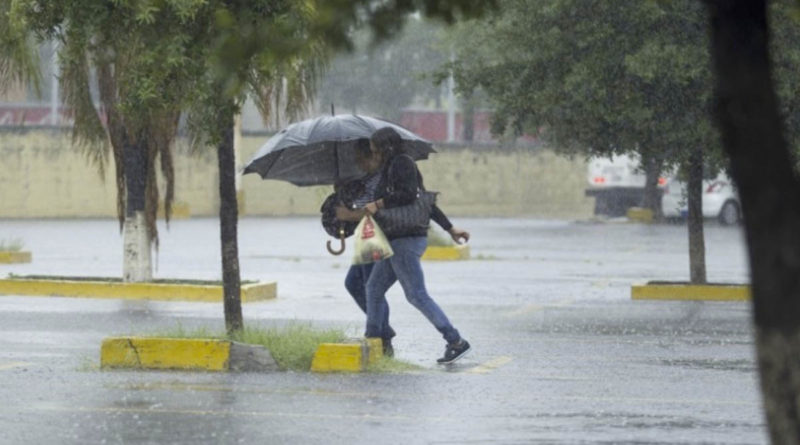 Personas corriendo bajo la lluvia en Managua