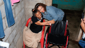 Reyna Rueda, alcaldesa de Managua entregando silla de rueda.
