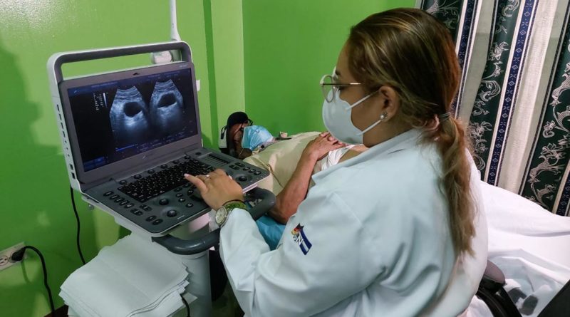 Médico del Ministerio de Salud de Nicaragua realizando ultrasonido a paciente masculino.