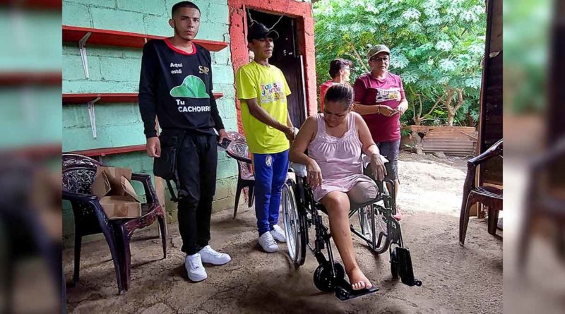 Jóvenes de Promotoría Solidaria junto a una protagonista durante la entrega de sillas de ruedas en Managua