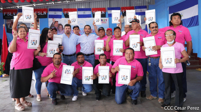 Representante de cooperativas de transporte urbano de Managua recibiendo títulos de propiedad por parte de las autoridades del Gobierno de Nicaragua.