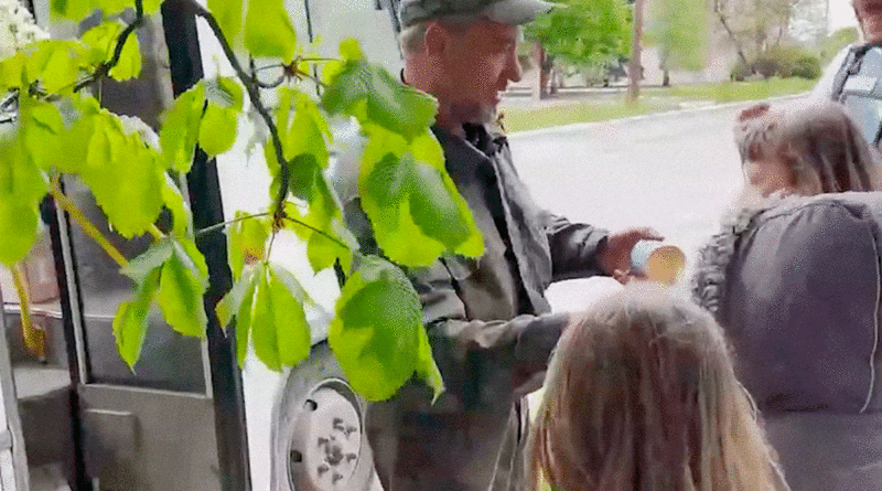 Conductor de un autobús de una misión humanitaria de la Milicia Popular de Donetsk entregando su ración de comida a unas niñas en un pueblo liberado de las fuerzas ucranianas