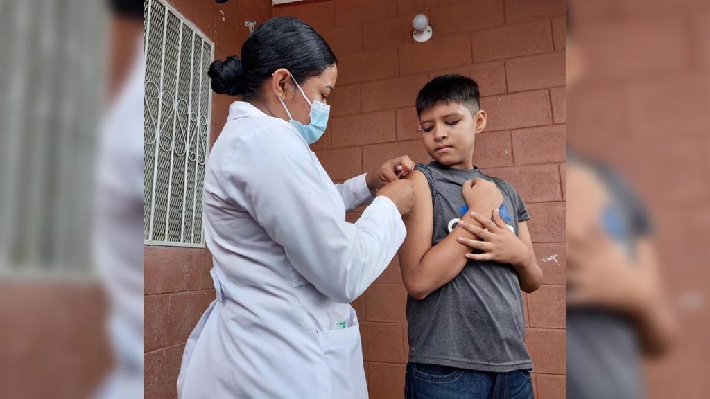 Brigadista del Ministerio de Salud aplica vacuna contra el COVID-19 a un menor de edad del barrio Santo Domingo