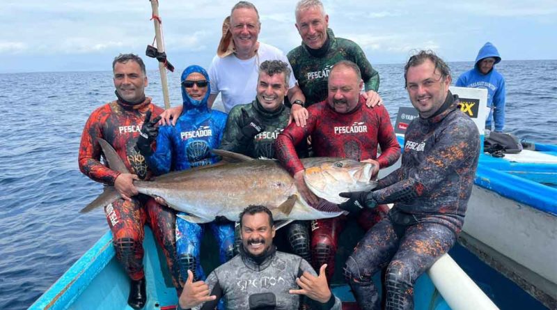 Grupo de pescadores sostienen un pez en sus manos