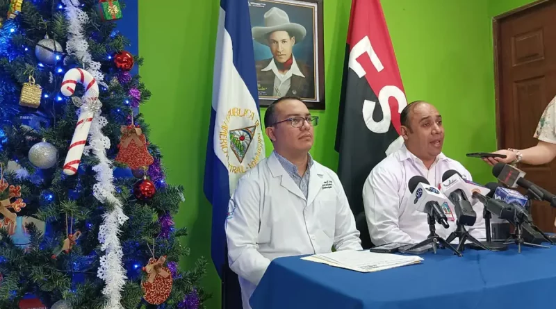 conferencia, salud, enfermedades, recomendaciones, temporada de frio, frio, evitar enfermedades, banderas, doctores, arbol de navidad, mesa, microfono,